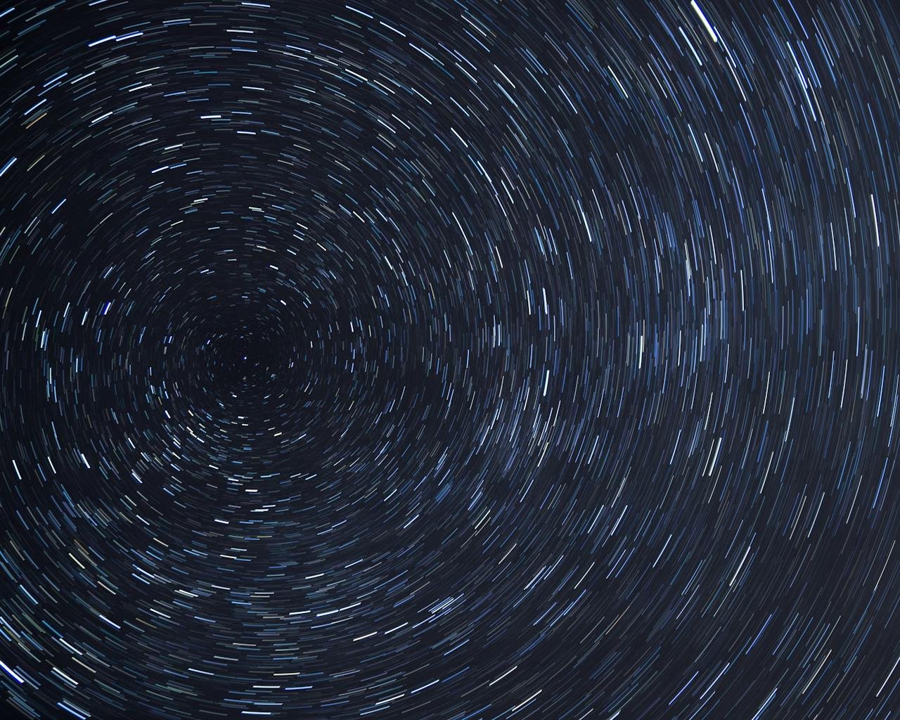 Dazzling star trails creating a spiral effect in the clear night sky.